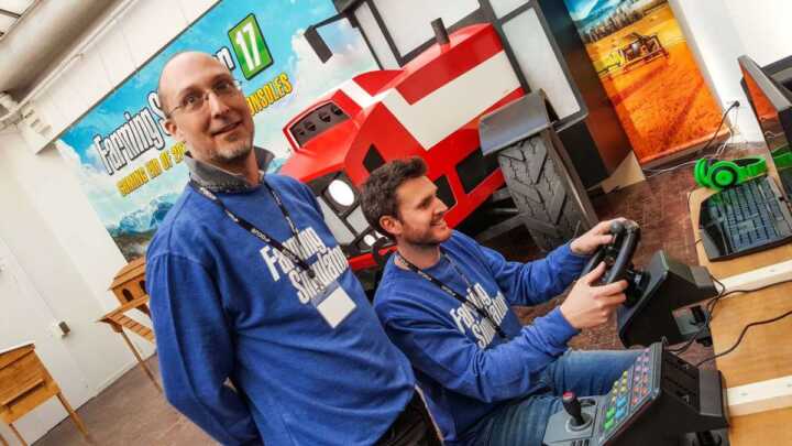 Martin Rabl, from Giants Software, tries his hand at MadCatz's dedicated Farming wheel, under the watchful eye of Marc Schwegler.